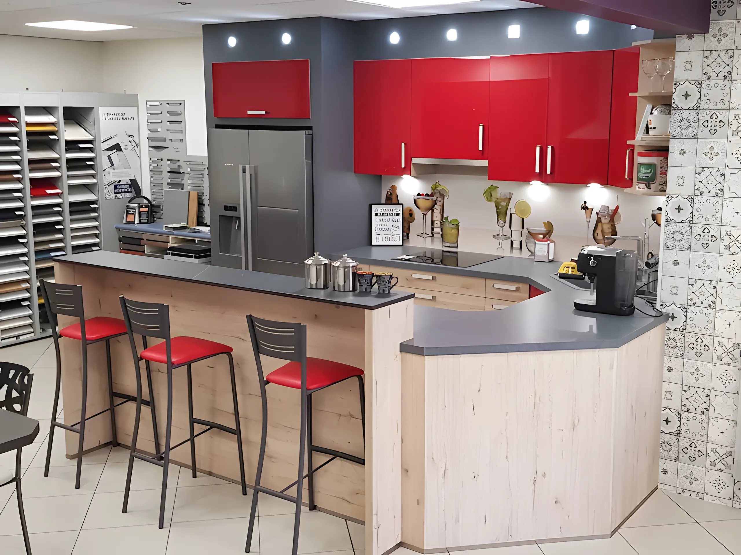Cuisine exposée au showroom : laque rouge, îlot bar en bois clair et tabourets rouges